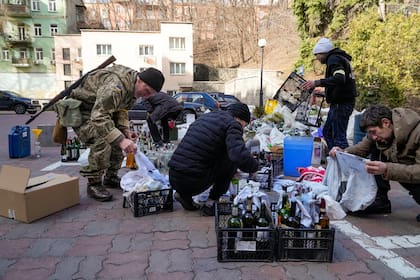 Miembros de la defensa civil preparan cocteles Molotov el domingo 27 de febrero en Kiev, Ucrania. (AP Foto/Efrem Lukatsky)
