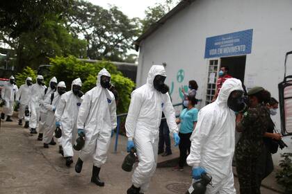 Miembros de las fuerzas armadas brasileñas con equipos de protección en el centro de salud mental Stella Maris, en Rio de Janeiro