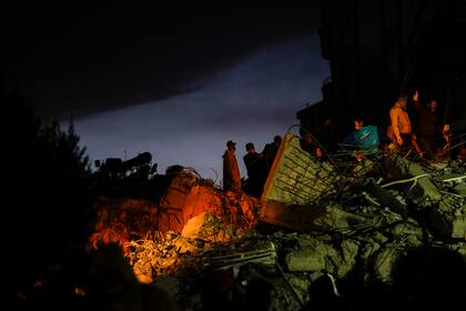Miembros de los equipos de emergencia buscan sobrevivientes entre los restos de un edificio destruido tras un sismo en Adana, Turquía, el 7 de febrero de 2023. (AP Foto/Francisco Seco)