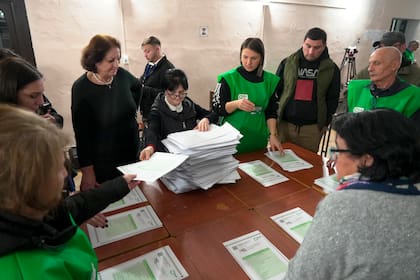 Miembros de una comisión electoral cuentan votos en Tiflis, Georgia, el 26 de octubre del 2024. (Foto AP/Kostya Manenkov)