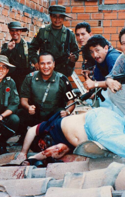 Miembros del Bloque de Búsqueda y de la DEA posando con el cadáver de Escobar sobre las tejas de una vivienda en Medellín como si fuese una presa de caza