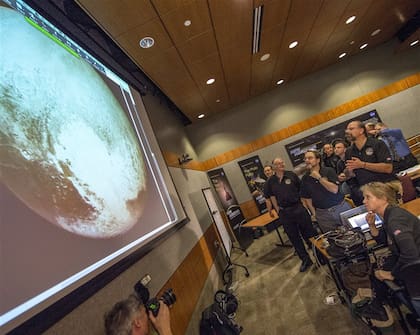 Miembros del equipo científico de la sonda New Horizons observan la imagen más precisa de Plutón