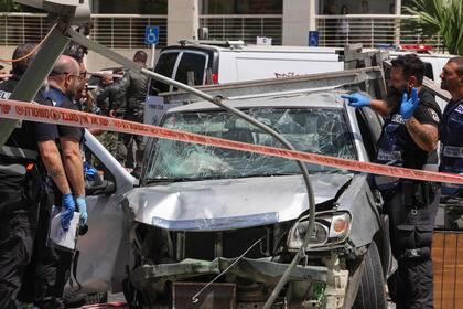 Miembros del personal de seguridad y emergencia israelí trabajan en el lugar de un informado ataque de embestida con auto en Tel Aviv el 4 de julio de 2023.
