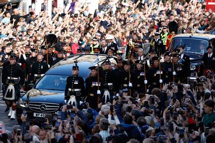 Miembros del público se reúnen para ver la procesión del féretro de la reina Isabel II, desde el Palacio de Holyroodhouse hasta la Catedral de St. Giles, en Edimburgo