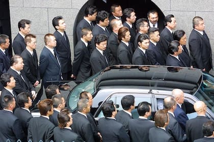 Miembros del sindicato Yamaguchi-gumi, uno de los principales de la yakuza, acuden al funeral de su oyabun en 2002.