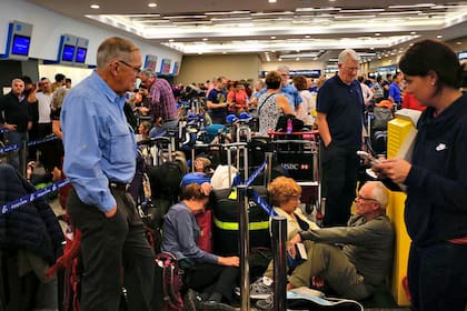 Mientras se realizaba la asamblea, los pasajeros se fueron acumulando en una fila que creció y creció hasta atravesar por completo el aeropuerto