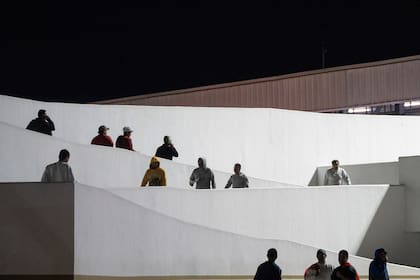 Migrantes caminan hacia México después de ser deportados de Estados Unidos, en el cruce peatonal fronterizo de El Chaparral, el 21 de enero de 2025, en Tijuana, México. (AP Foto/Félix Márquez)