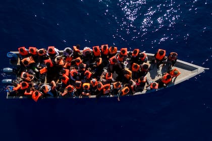 Migrantes de Eritrea, Libia y Sudán navegan en un bote de madera antes de ser asistidos por trabajadores humanitarios de la ONG española Open Arms, en el mar Mediterráneo (Foto AP/Joan Mateu Parra, Archivo)