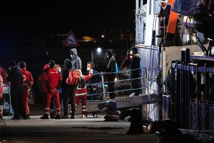 Migrantes desembarcan del buque de rescate Humanity 1, gestionado por la organización alemana SOS Humanity en el puerto de Catania, Sicilia, en el sur de Italia, el domingo 6 de noviembre de 2022. (AP Foto/Salvatore Cavalli)