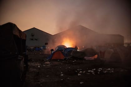 Migrantes en un campamento improvisado antes de ser desalojados en Grande-Synthe, Francia, el martes 16 de noviembre de 2021. (AP Foto/Louis Witter)
