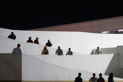 Migrantes entran a pie a México tras haber sido deportados desde Estados Unidos, en el paso peatonal de El Chaparral, en Tijuana, México, el 21 de enero de 2025. (AP Foto/Felix Marquez)