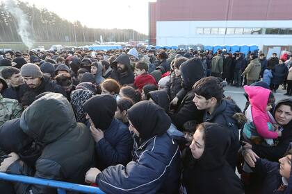 Migrantes forman cola para recibir comida cerca de un centro de logística en el cruce "Kuznitsa" en la frontera Bielorrusia-Polonia cerca de Grodno, Bielorrusia, el 20 de noviembre del 2021. (Maxim Guchek/BelTA via AP)