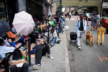 Migrantes forman fila frente al Roosevelt Hotel que la ciudad de Nueva York emplea como alojamiento temporario (Archivo)