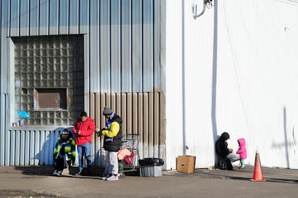 Migrantes frente a un refugio en el barrio de Pilsen de Chicago, el martes 19 de diciembre de 2023; la capacidad de la ciudad está rebasada ante el número de llegadas (archivo)