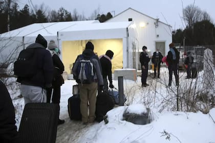Migrantes hacen fila en un centro de recepción para cruzar de forma irregular desde Champlain, Nueva York, hacia Saint-Bernard-de-Lacolle, provincia de Québec, Canadá