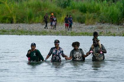 Migrantes haitianos vadean el río Tuquesa después de caminar por el Tapón del Darién, el miércoles 4 de octubre de 2023, en Bajo Chiquito, Panamá (AP Foto/Arnulfo Franco, Archivo)