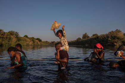 Migrantes, muchos de ellos de Haití, vadean el Rio Grande entre Estados Unidos y México el martes, 21 de septiembre del 2021. (AP Foto/Julio Cortez)