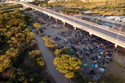 Migrantes, muchos de ellos haitianos, están acampados bajo el puente internacional Del Rio cerca del río Bravo, jueves 23 de setiembre de 2021, en Del Rio, Texas, EEUU. (AP Foto/Julio Cortez)