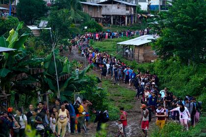 Migrantes que buscan llegar a Estados Unidos hacen fila para tomar un bote en Bajo Chiquito, en la provincia de Darién en Panamá, el jueves 5 de octubre de 2023, después de caminar a través de la selva del Darién desde Colombia. (AP Foto/Arnulfo Franco)