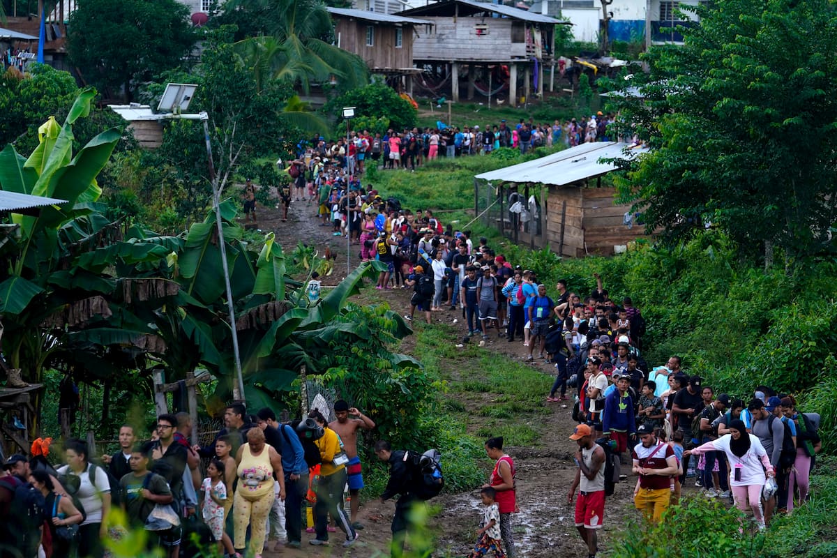 Migrantes que buscan llegar a Estados Unidos hacen fila para tomar un bote en Bajo Chiquito, en la provincia de Darién en Panamá