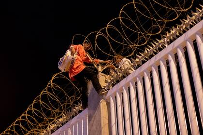 Migrantes que cruzaron recientemente la frontera española en Marruecos, tratan de llegar al puerto comercial de Ceuta, España, el miércoles 19 de mayo de 2021. (AP Foto/Bernat Armangue)