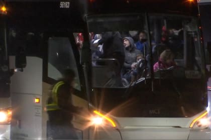 Migrantes suben a un autobús luego de llegar al Aeropuerto Internacional Rockford de Chicago, procedentes de San Antonio Texas, a la 1 de la mañana del 1 de enero de 2024, en Rockford, Illinois