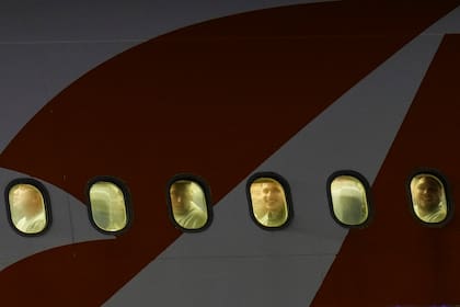 Migrantes venezolanos deportados se asoman por las ventanillas de un avión a su llegada al Aeropuerto Internacional Simón Bolívar