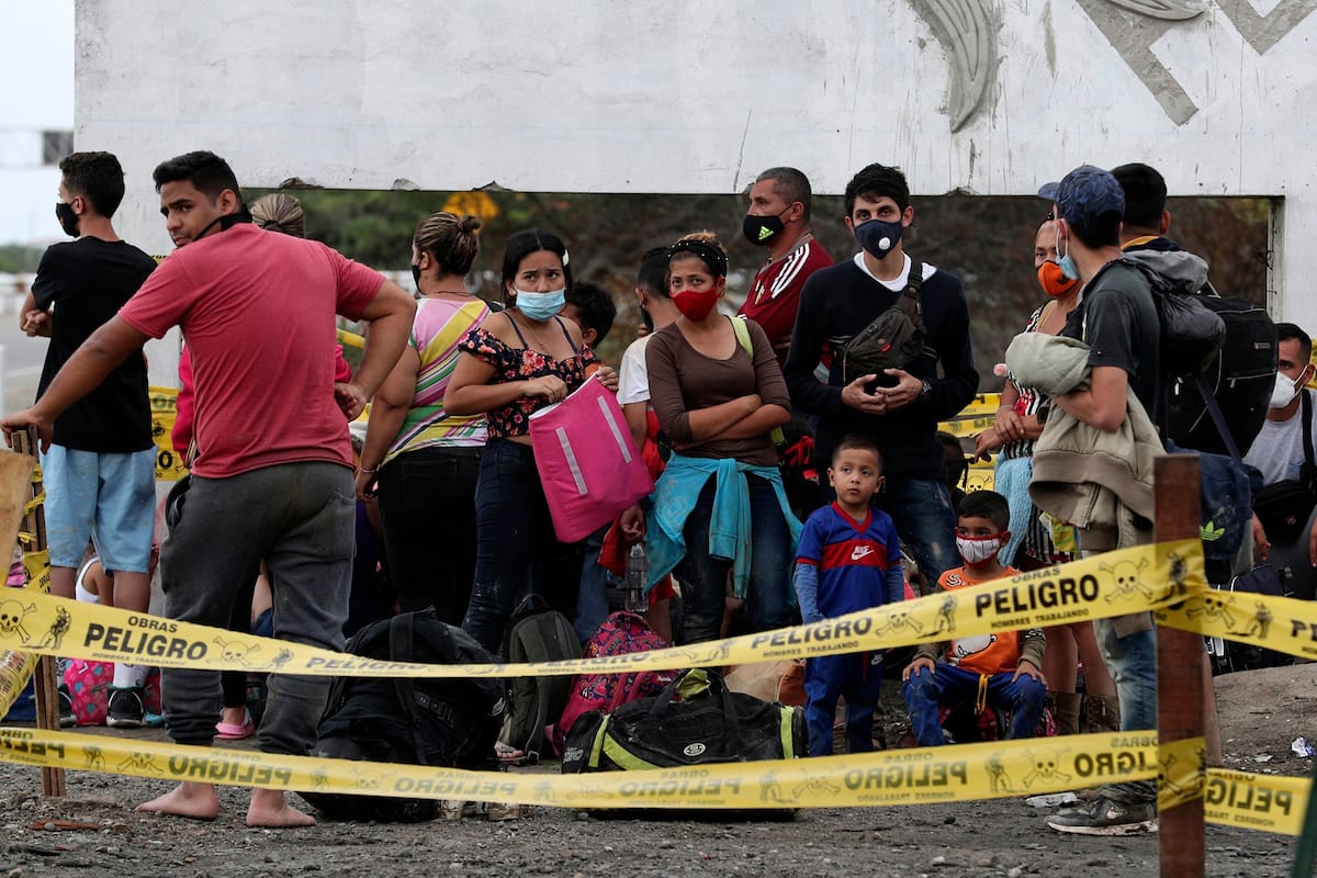 Migrantes venezolanos esperan en un puesto de control para ser transportados de regreso a Ecuador, en Tumbes, Perú, el viernes 29 de enero de 2021.
