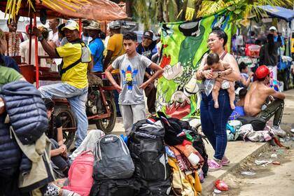 Migrantes venezolanos esperan subir a un barco en el puerto colombiano de Necoclí para seguir camino hacia Estados Unidos (Danilo Gómez/AFP)