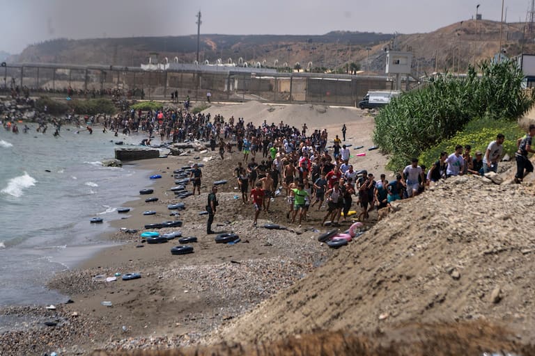Migrants cross from Morocco into the Spanish enclave of Ceuta, Thursday, July 30, 2026. (AP Photo/Antonio Sempere)