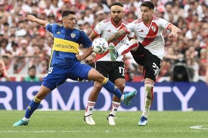 Miguel Merentiel luchando con Cristian Villagra en presencia de Paulo Díaz; Boca y River se cruzarán este domingo en un cuarto de final por la Copa de la Liga Profesional.