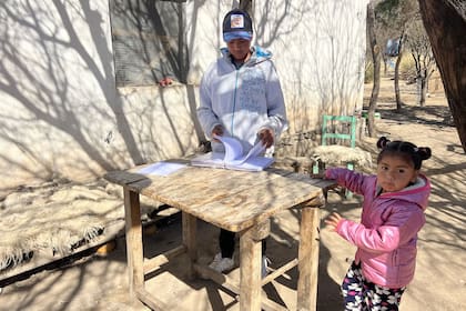 Miguel se sienta a la sombra a hacer la tarea y mostrar sus carpetas del colegio. "Quiero aprender más", dice.