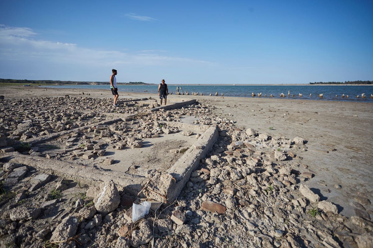 Miguel Torres y Marcos Tobar miran parte de la antigua finca que la baja del agua dejó al descubierto en el dique El Carrizal