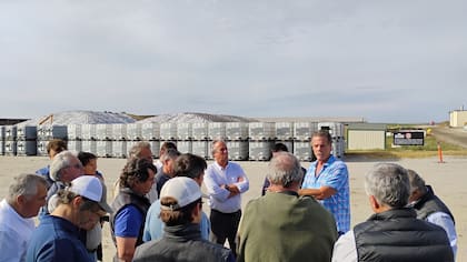 Mike McCloskey (camisa a cuadros) explica el sistema al grupo de la Fundación Producir Conservando. Detrás, los silos de maíz y los contenedores de la planta de tratamiento