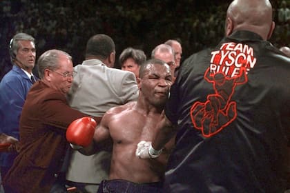 Mike Tyson fuera de control; tras morder a Evander Holyfield es descalificado y ni siquiera los integrantes de su equipo pueden detenerlo