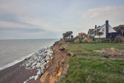 Miles de hogares a lo largo de la costa este de Inglaterra están amenazados por los acantilados que se erosionan rápidamente y colindan con el Mar del Norte. Una casa en el pueblo de Thorpeness se encuentra a unos 12 metros del borde.