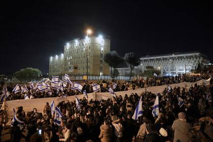 Miles de nacionalistas israelíes protestan frente al edificio del parlamento en Jerusalén, el jueves 13 de enero de 2022, para exigir al gobierno que se abstenga de evacuar un asentamiento en Cisjordania. (AP Foto/Ariel Schalit)