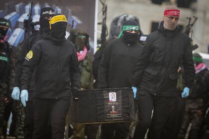 Milicianos palestinos cargan el ataúd del bebé rehén israelí Kfir Bibas para entregarlo a la Cruz Roja en Jan Yunis, Franja de Gaza, el 20 de febrero del 2025
