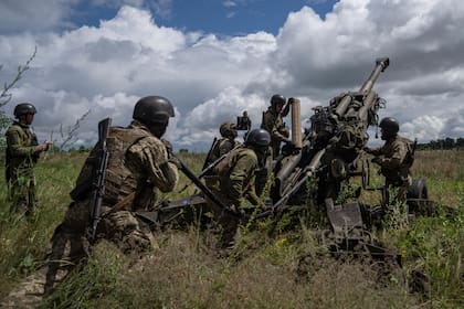 Militares ucranianos se preparan para disparar un obús M777 suministrado por Estados Unidos contra posiciones rusas desde la región de Kharkiv, Ucrania. (AP Foto/Evgeniy Maloletka)
