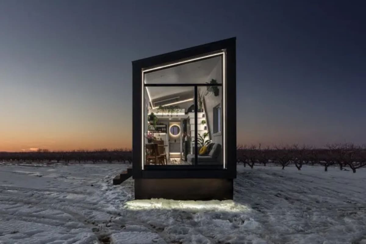 Minicasa revestida en acero de color negro sobre un terreno nevado