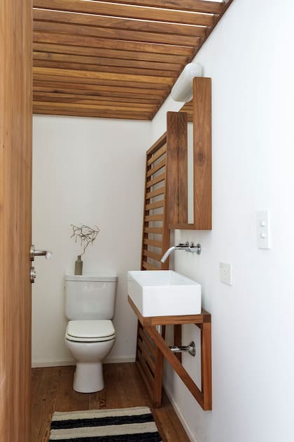 Mismo material con distinto tratamiento en el toilette, con un toallero símil elástico de cama que llena el espacio decorativamente, pero sin invadirlo