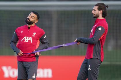 Mohamed Salah (izquierda) usa una cinta de resistencia con Dominik Szoboszlai, su compañero de Liverpool, durante un entrenamiento