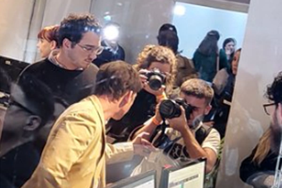 Momento en que Santiago Caputo le mira la credencial al fotógrafo Antonio Becerra