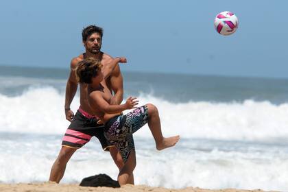Momo,
el hijo que la actriz tuvo
con Daniel Osvaldo,
jugando a la pelota en la playa con
Matías Palleiro.