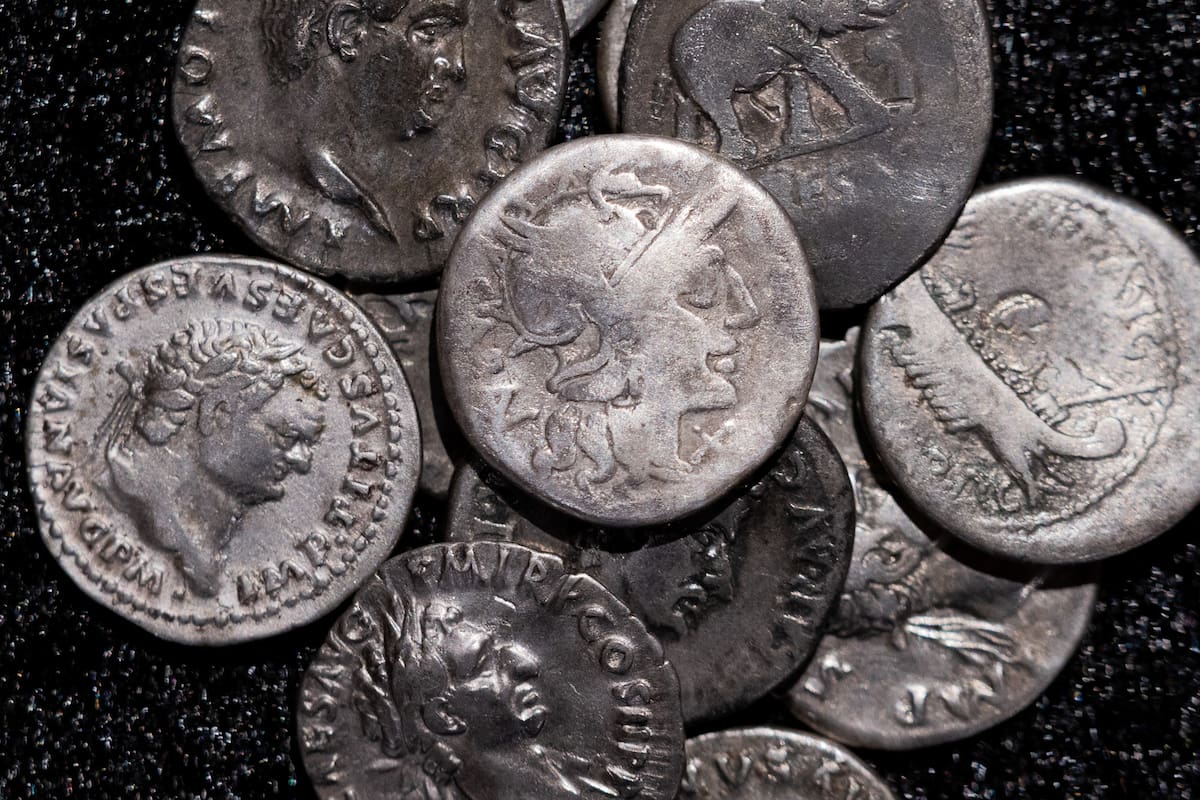 Monedas romanas, incluida la que se muestra en el centro, que data del año 148 a. C., cuando Roma aú