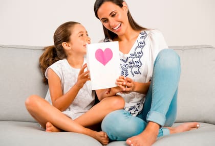Mother receiving a greeting card on mother's day from her daughter