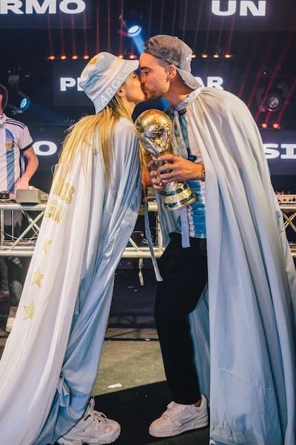 ¡Mucho por celebrar! Lookeados de celeste y blanco de pies a cabeza, los novios se besan con la copa en mano.
