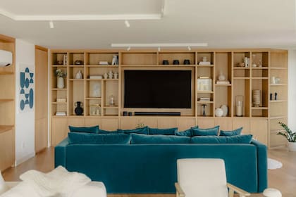 Mueble a medida (Ciroman) enchapado en roble y con iluminación LED oculta en los estantes. A la izquierda, obra de la artista Francesca Molinari a tono con el sillon.