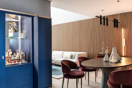 Mueble (Aline Roman Arquitetura) exento, laqueado en azul. Tiene puertas corredizas empotradas, que quedan ocultas al correrse y permiten también cerrar por completo el bar.