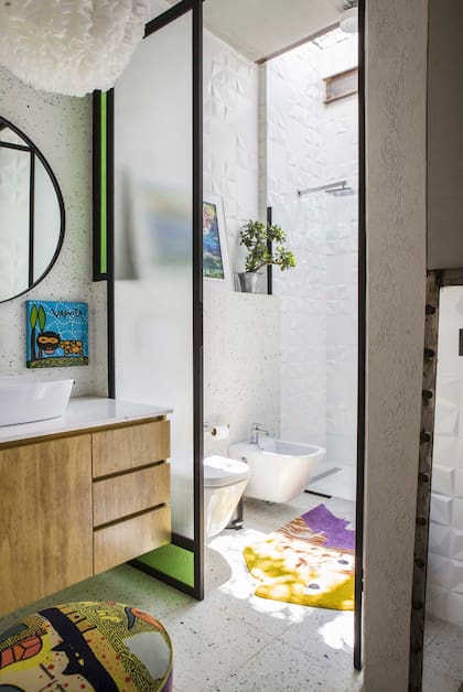 Mueble con mesada de mármol, puf y obra de Milo Lockett.